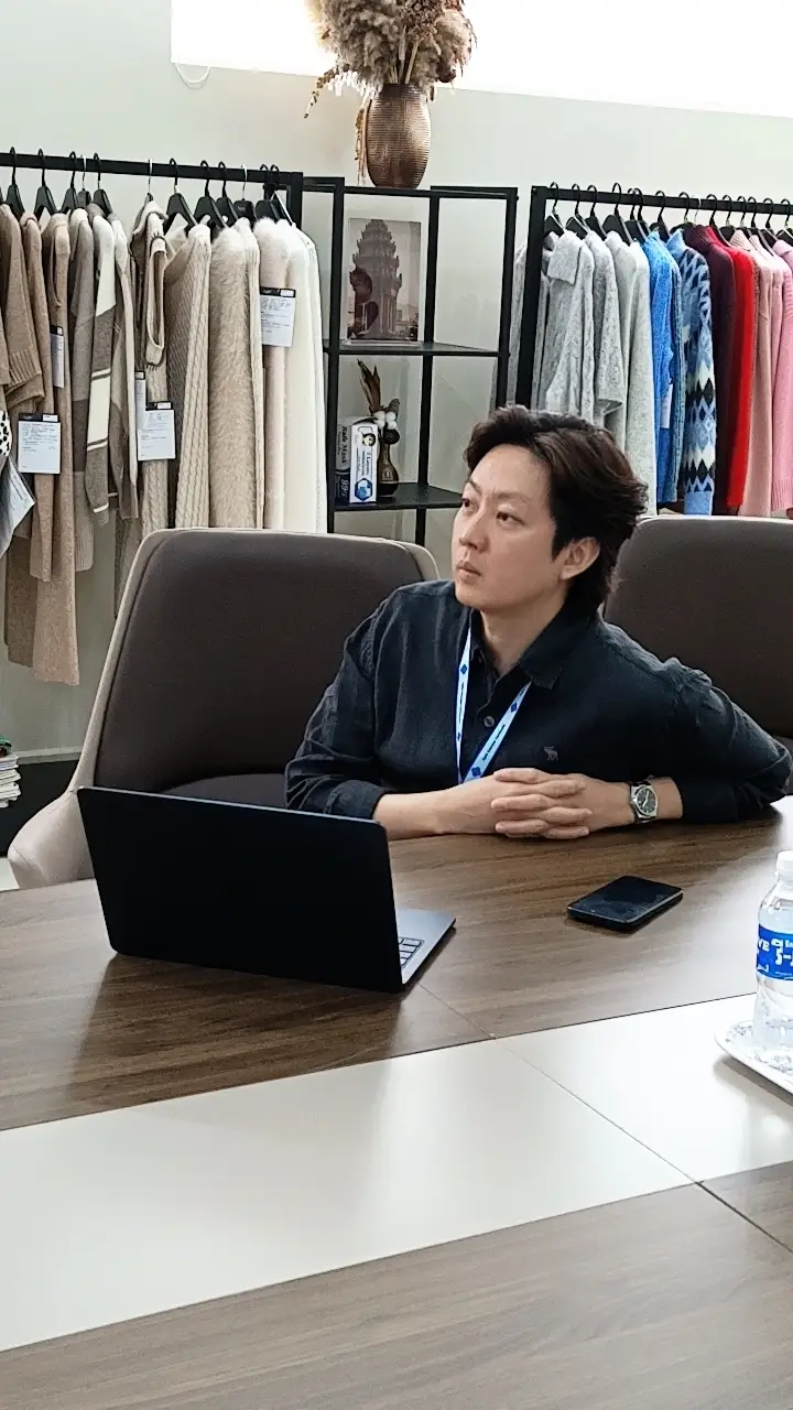 Agile Sweaterのショールームで説明に耳を傾ける参加者